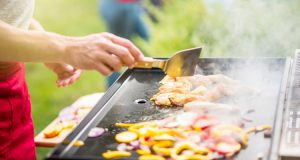 Plancha en inox avec du poulet et des légumes